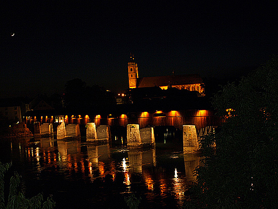 Münster und Holzbrücke bei Nacht